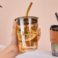Reusable glass tumbler with a lid and straw